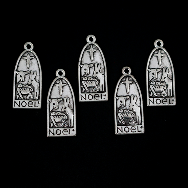 Arched charm depicting Christ child in the manger with the Christmas Star or the Star of Bethlehem above and a donkey and cow on either side