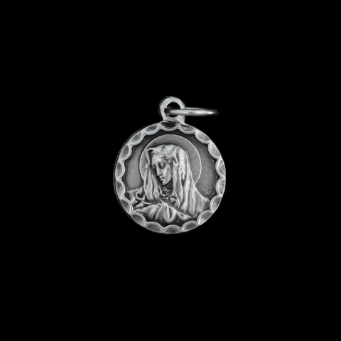Our Lady of Sorrows medal that has a unique scalloped border. The backside is blank.