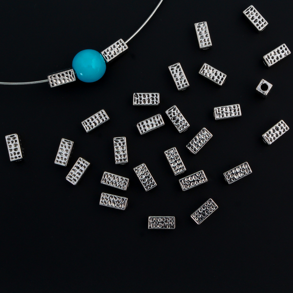 Rectangle shaped spacer beads that have a dimple dot pattern on all four sides 6mm x 3mm