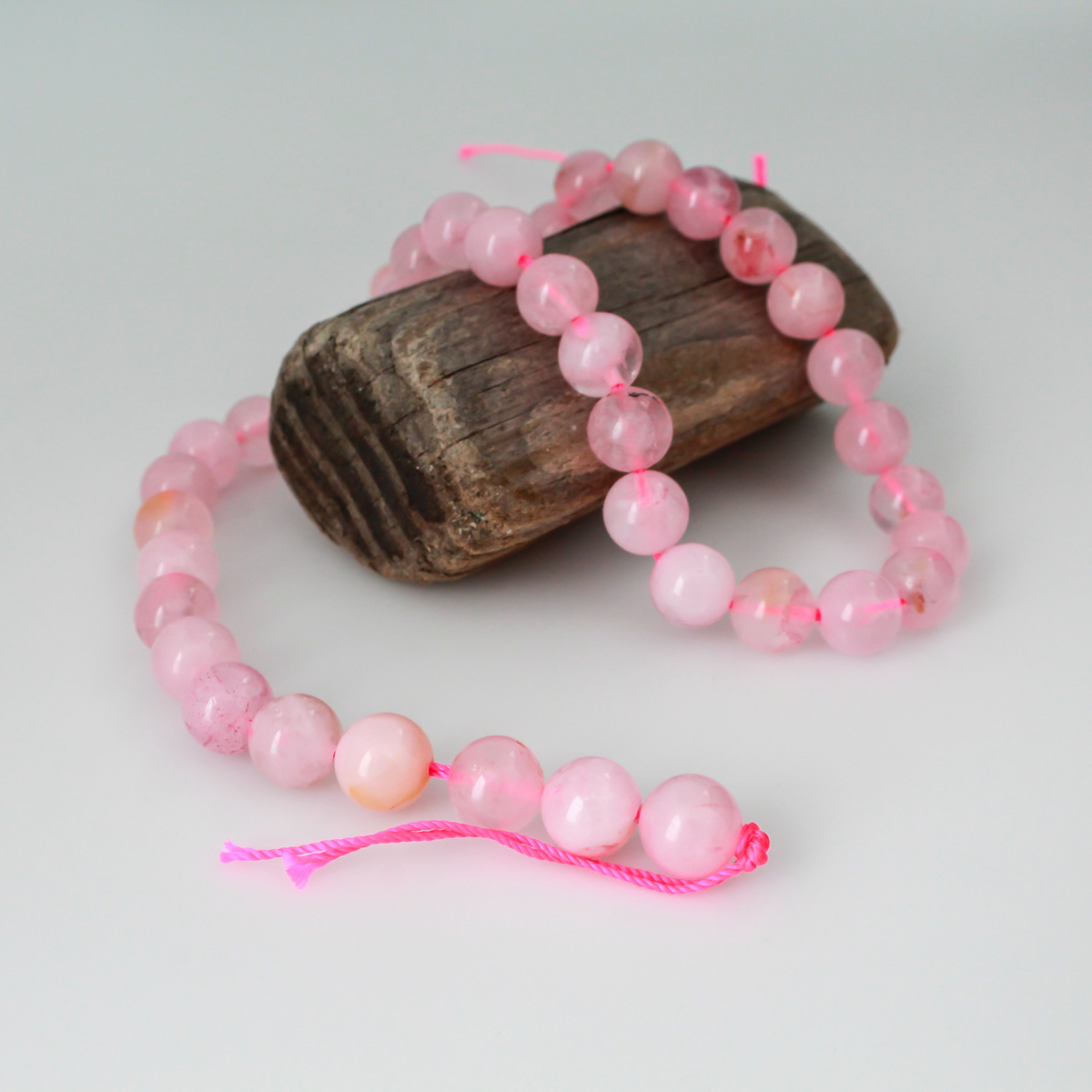 Natural rose quartz beads sold per strand. These are a soft muted pink color, some are transparent.