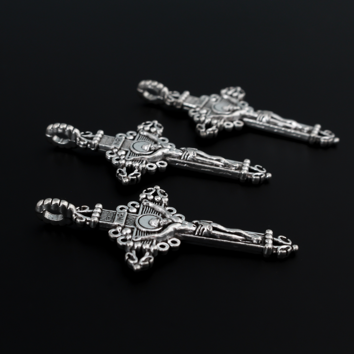 Three ornate crucifix crosses in an antiqued silver-tone color. This is a larger size crucifix measuring 2" long