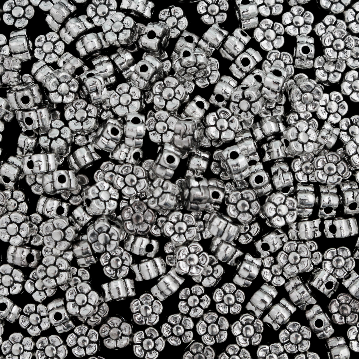 silver-tone metal beads that are flat with a raised relief five petal flower pattern on both sides