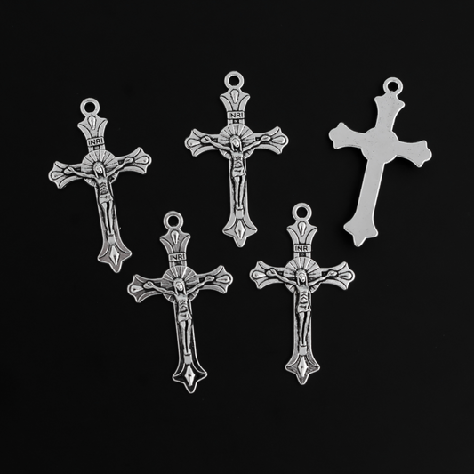 Small crucifix cross in an antiqued silver color with a starburst design behind Jesus and ornate flared ends.