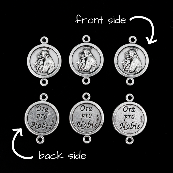 Saint Anthony round flat connector links that are silver oxidized plating on a base metal. The backside is marked "Ora Pro Nobis" in Latin which translates to pray for us.