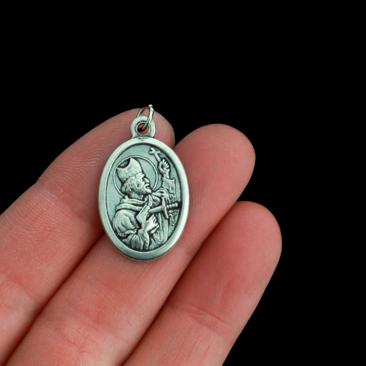 Saint Boniface medal that depicts the saint on the front with a pierced book and cross, the backside is marked "Pray For Us".