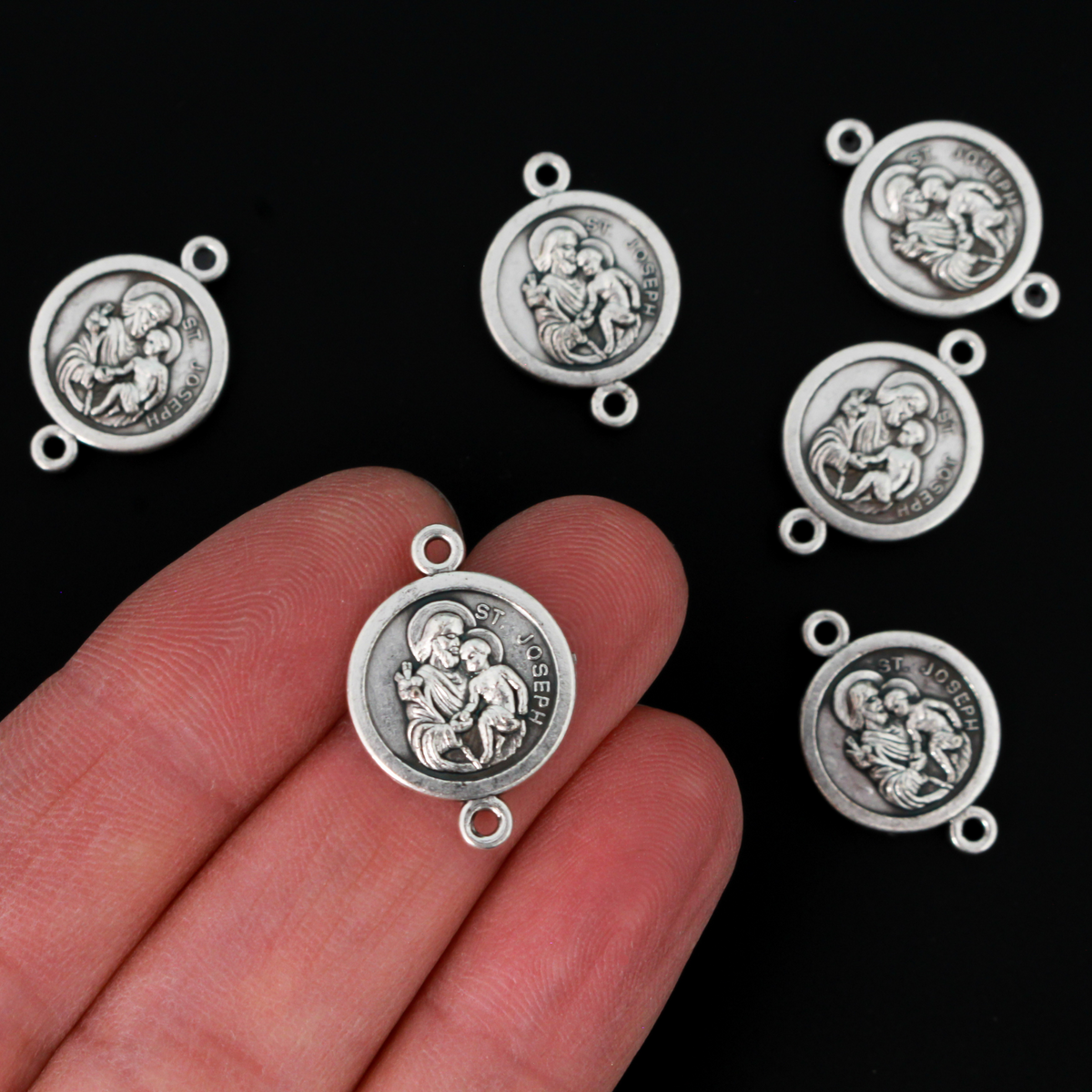 Saint Joseph round flat connector links that are silver oxidized plating on a base metal. The backside is marked "Ora Pro Nobis" in Latin which translates to pray for us