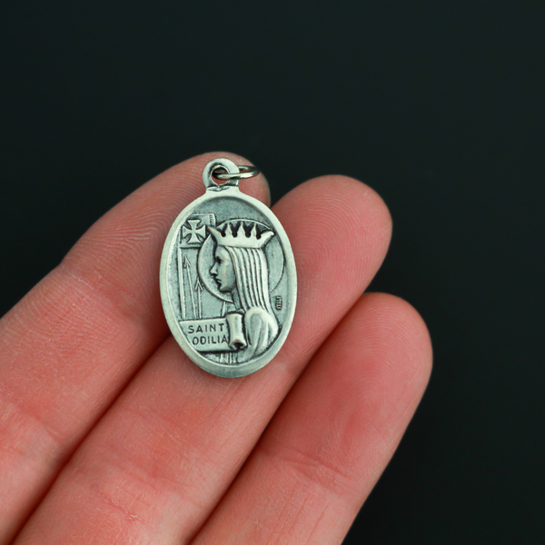 Saint Odilia medal that depicts the saint on the front and is marked "Pray For Us" on the back