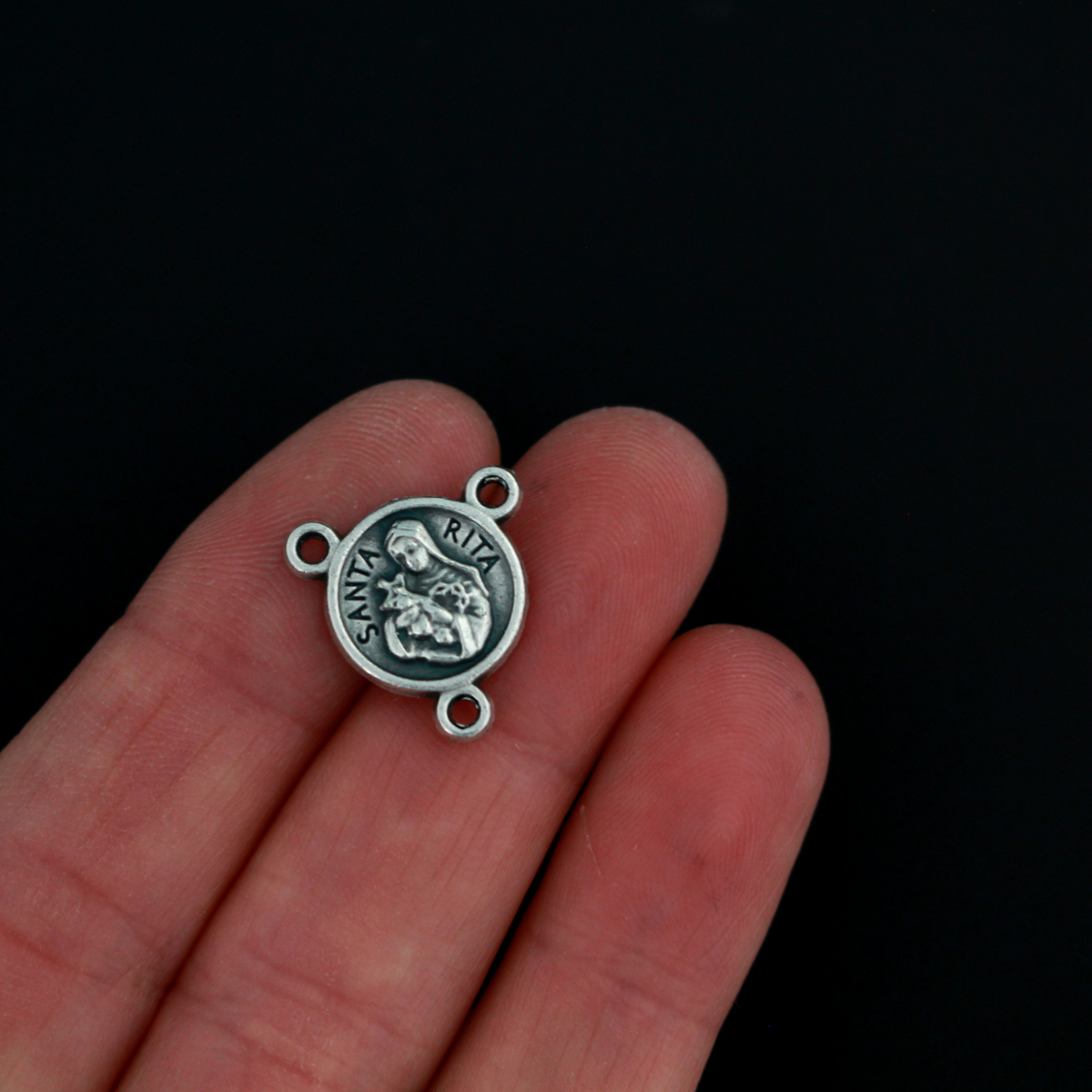 A beautiful rosary centerpiece that features an image of Saint Rita on the front and a rose on the back