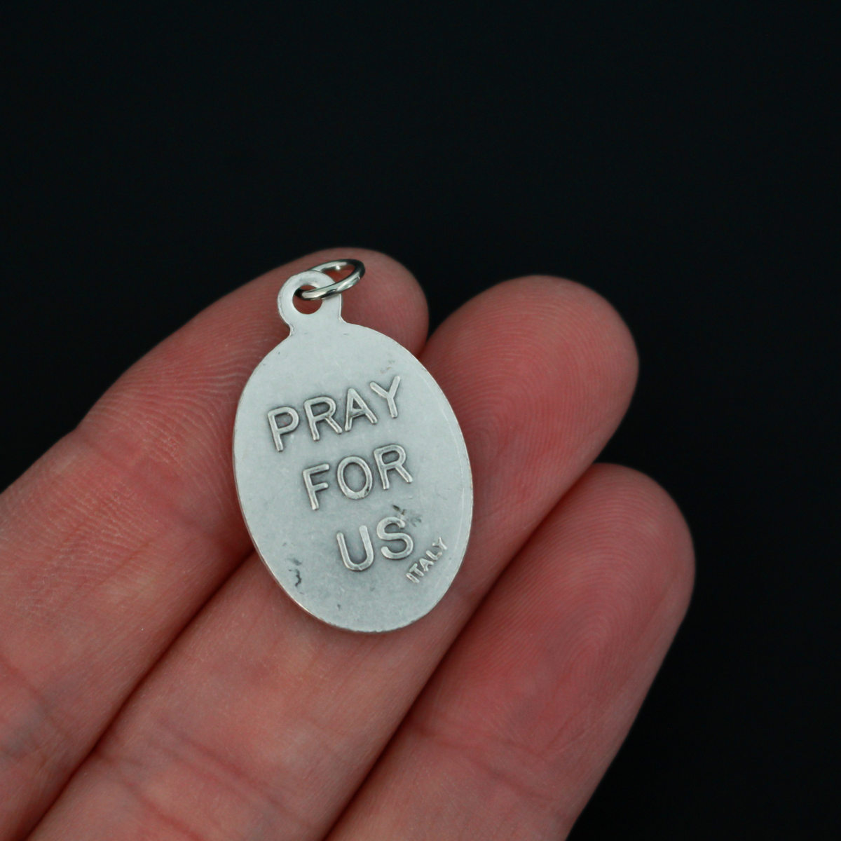 Holy Mother Saint Scholastica medal that depicts the saint on the front and is marked "Pray For Us" on the back