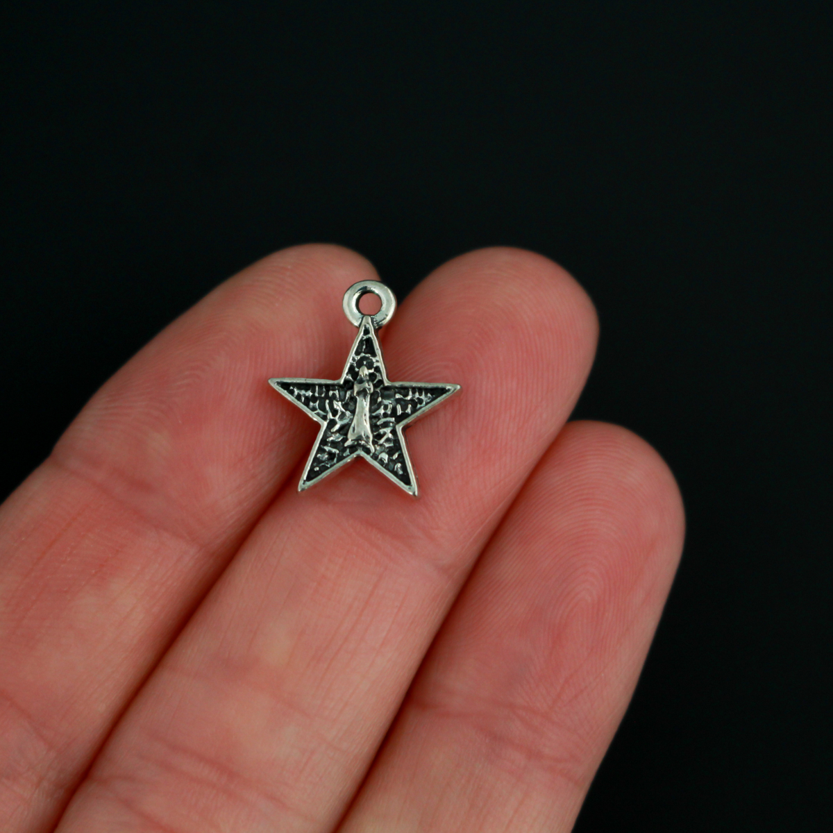 Small star-shaped charms that feature The Blessed Virgin Mary as Our Lady of the Sea on the front side and an anchor on the backside.