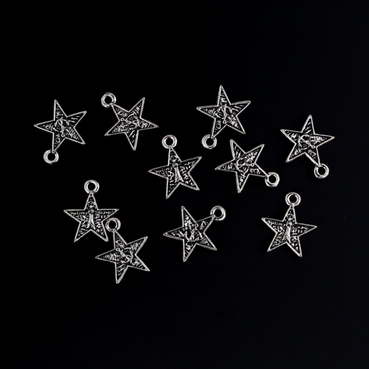 Small star-shaped charms that feature The Blessed Virgin Mary as Our Lady of the Sea on the front side and an anchor on the backside.