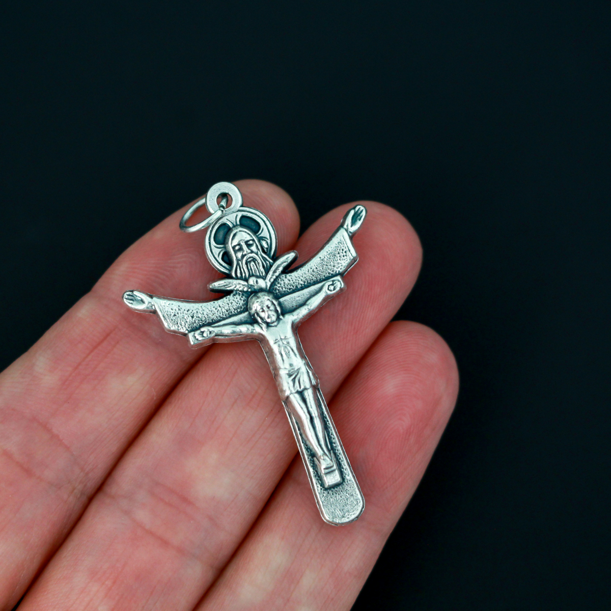 Holy trinity crucifix with the father, the son, and the holy ghost represented on the front of the crucifix. The backside of the cross is marked "Tertium Millennium" with the Greek letters Alpha and Omega