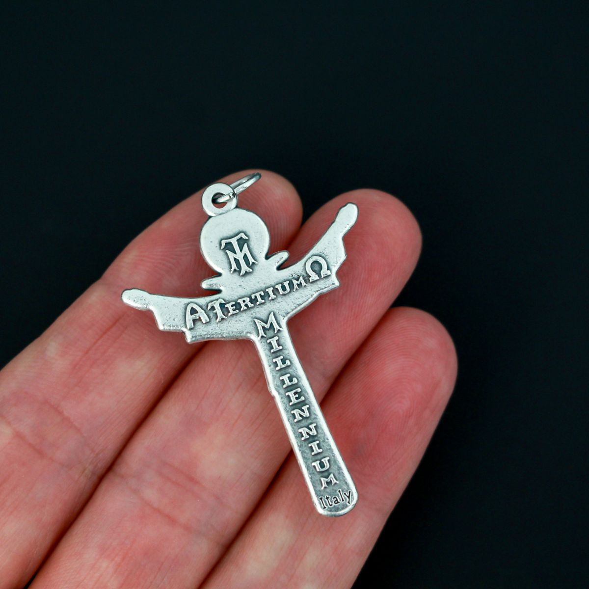 Holy trinity crucifix with the father, the son, and the holy ghost represented on the front of the crucifix. The backside of the cross is marked "Tertium Millennium" with the Greek letters Alpha and Omega