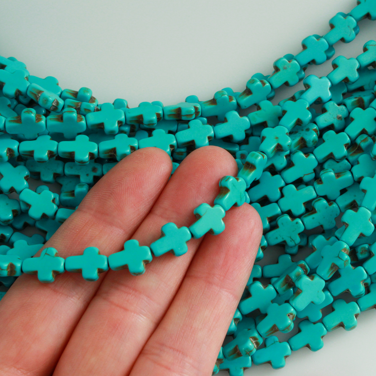 Turquoise cross shaped beads that are a synthetic turquoise material, 10x8x3mm