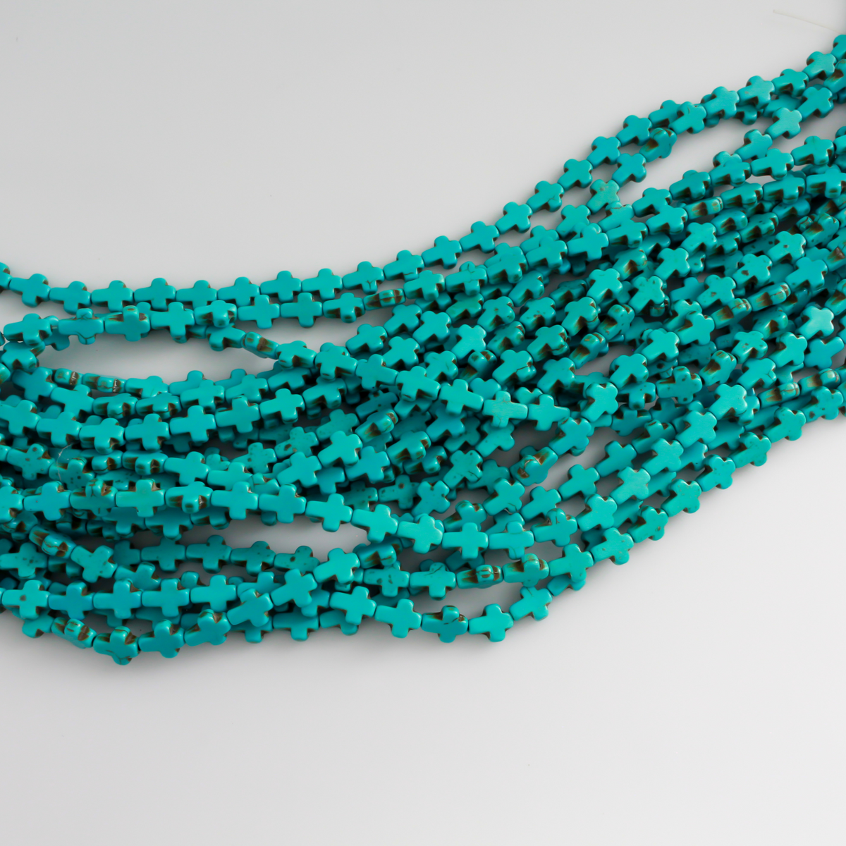 Turquoise cross shaped beads that are a synthetic turquoise material, 10x8x3mm