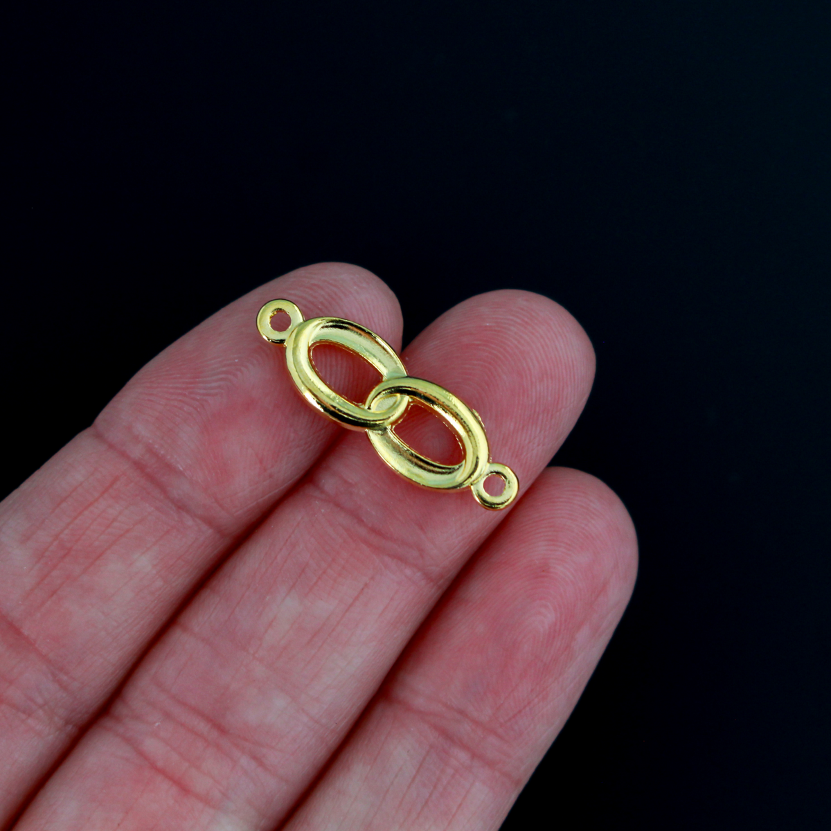 Connector links that are intertwined wedding rings in a shiny gold color