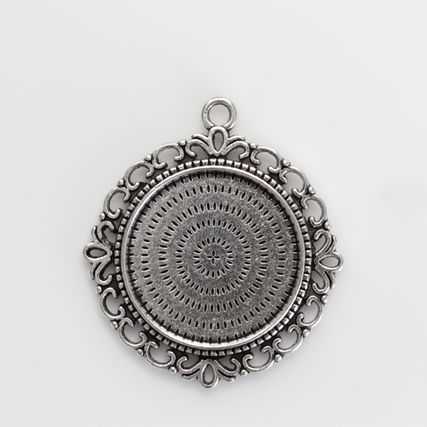 Zinc alloy round bezel with an ornate filigree border. The tray size on this bezel is 25mm