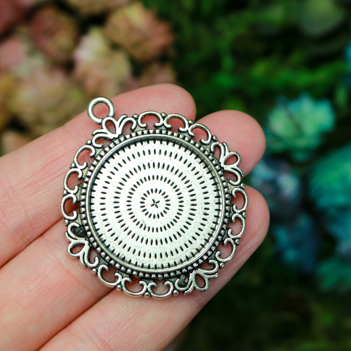 Zinc alloy round bezel with an ornate filigree border. The tray size on this bezel is 25mm