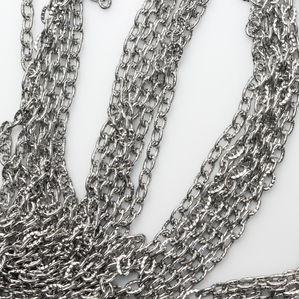 Iron cable chain that has unsoldered links that are flat and oval in shape with a textured design, three meters in length