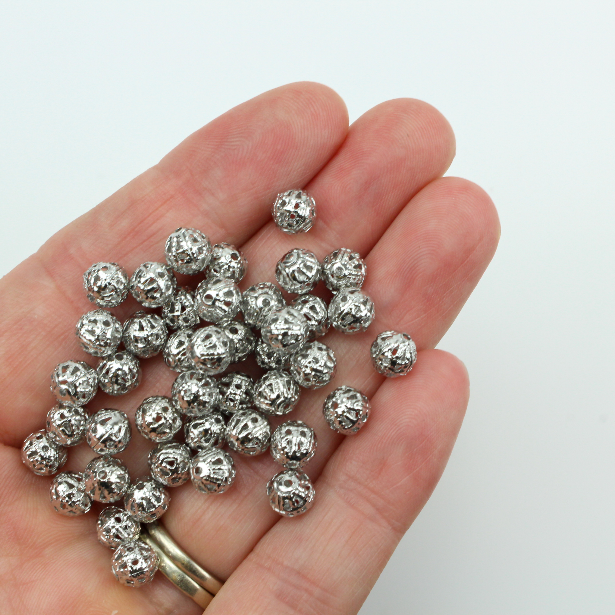 6mm lightweight metal beads are hollow with a cutout filigree design and an antiqued silver color