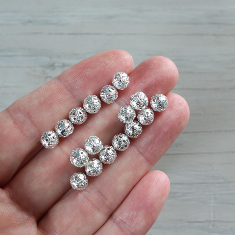 6mm lightweight metal beads that are hollow with a cutout (filigree) design and a shiny platinum silver color