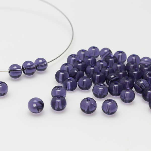 6mm round glass beads that are a transparent purple color.