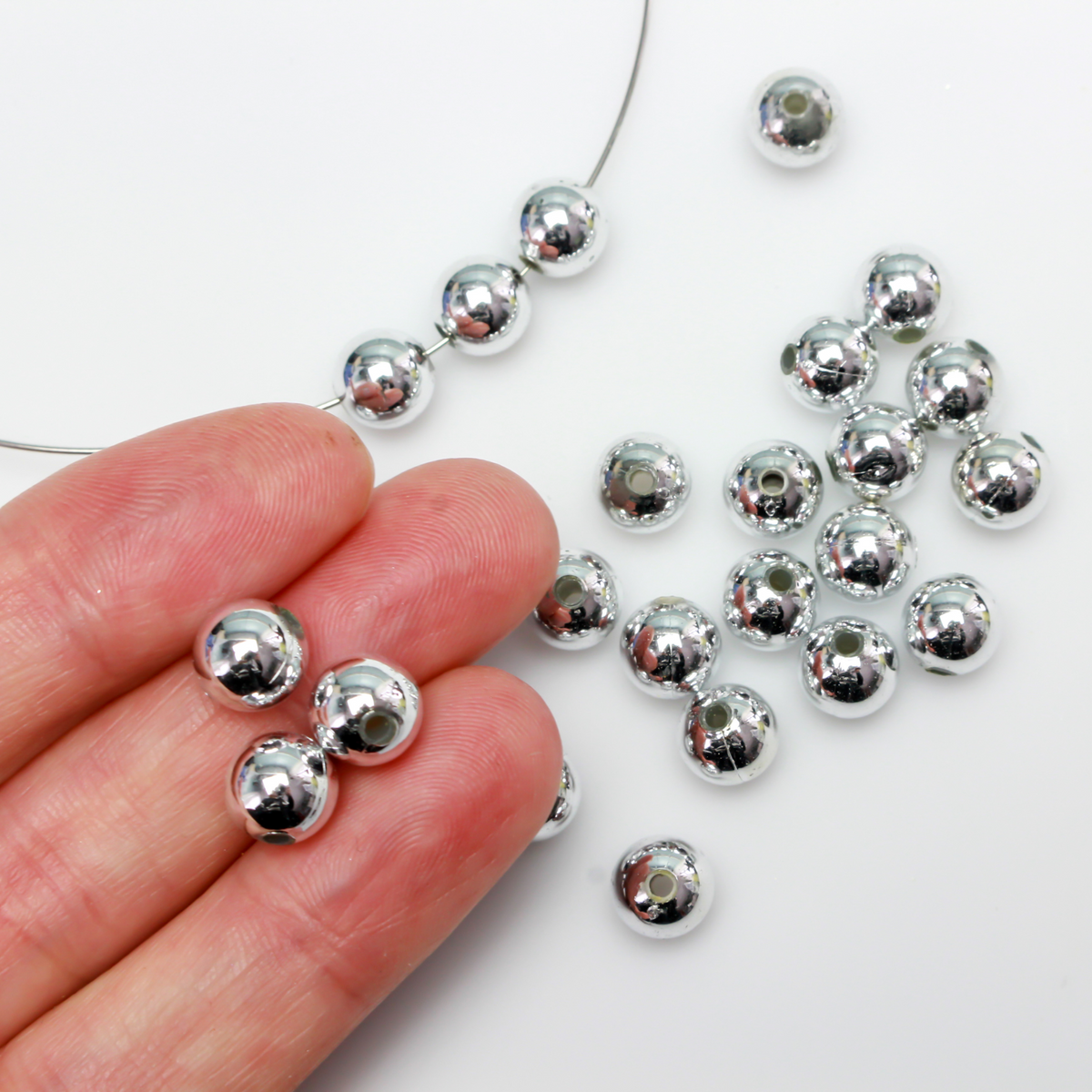 8mm round plastic beads with a shiny silver metallic plating. 