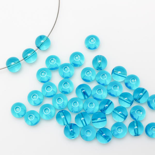 8mm round glass beads in a transparent aquamarine blue color.