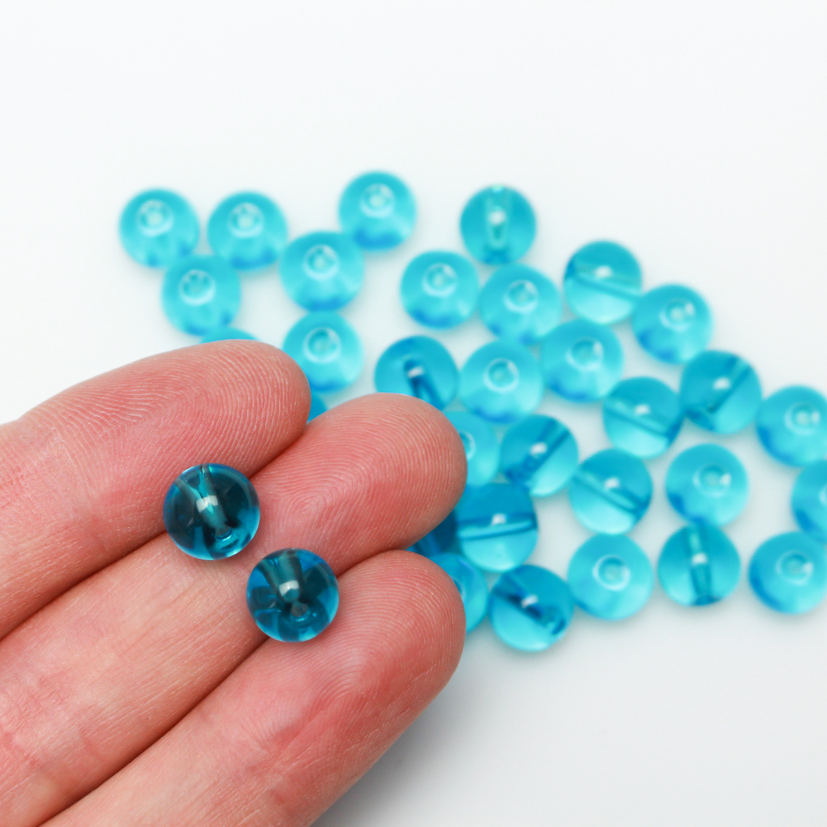 8mm round glass beads in a transparent aquamarine blue color.