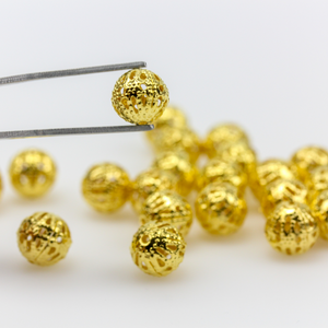 8mm round lightweight metal beads that are hollow with a cutout (filigree) design and a shiny gold finish