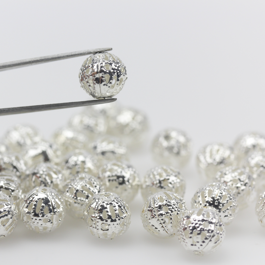 8mm lightweight metal beads that are hollow with a cutout (filigree) design and a shiny platinum silver color