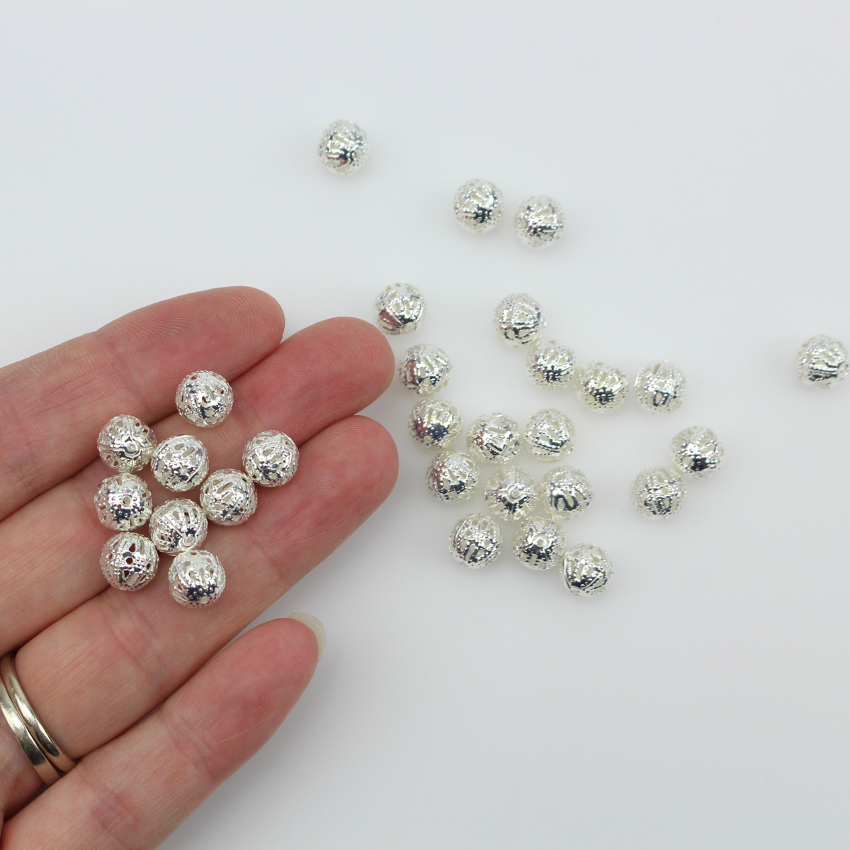 8mm lightweight metal beads that are hollow with a cutout (filigree) design and a shiny platinum silver color