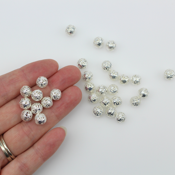 8mm lightweight metal beads that are hollow with a cutout (filigree) design and a shiny platinum silver color