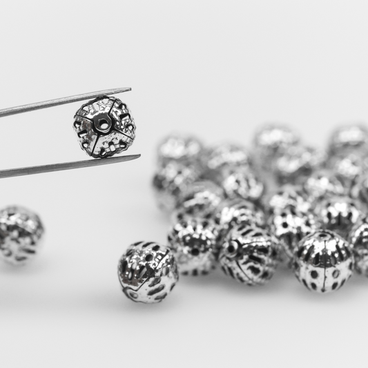 8mm round lightweight metal beads that are hollow with a cutout (filigree) design and an antiqued silver color