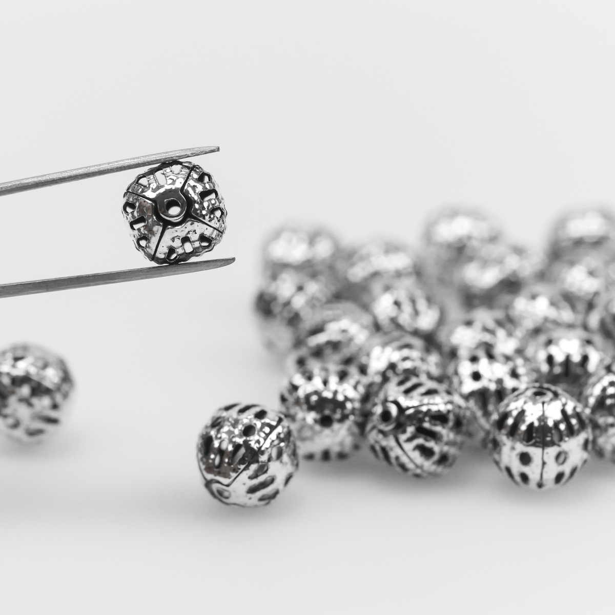 6mm lightweight metal beads are hollow with a cutout filigree design and an antiqued silver color