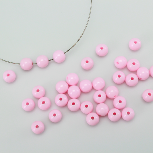 Round pale pink opaque beads that are 8mm in diameter with a 1.5mm hole size.