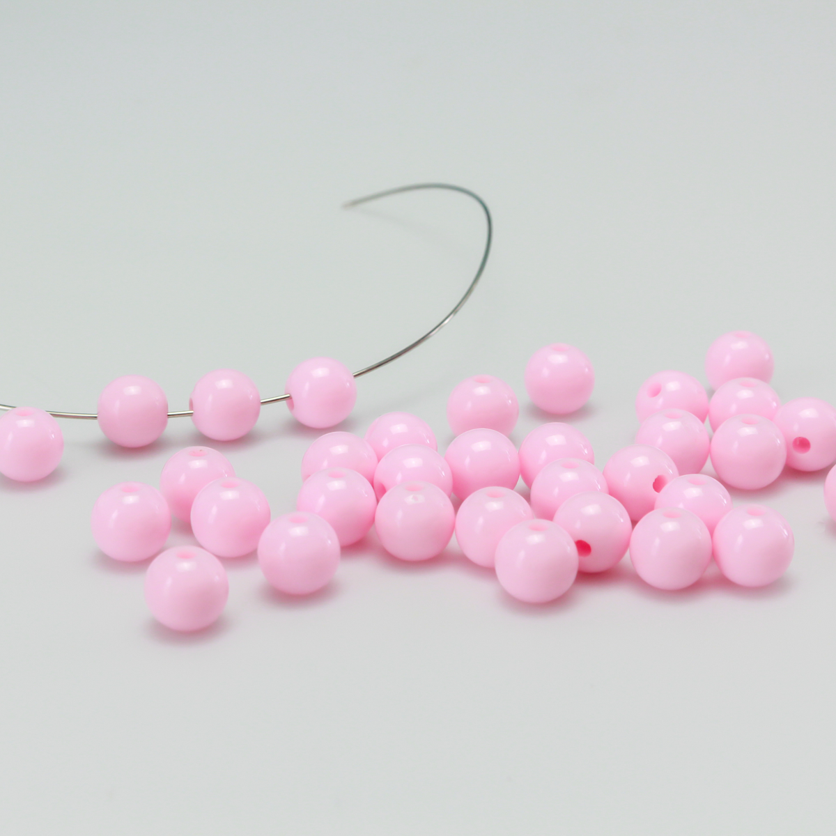 Round pale pink opaque beads that are 8mm in diameter with a 1.5mm hole size.