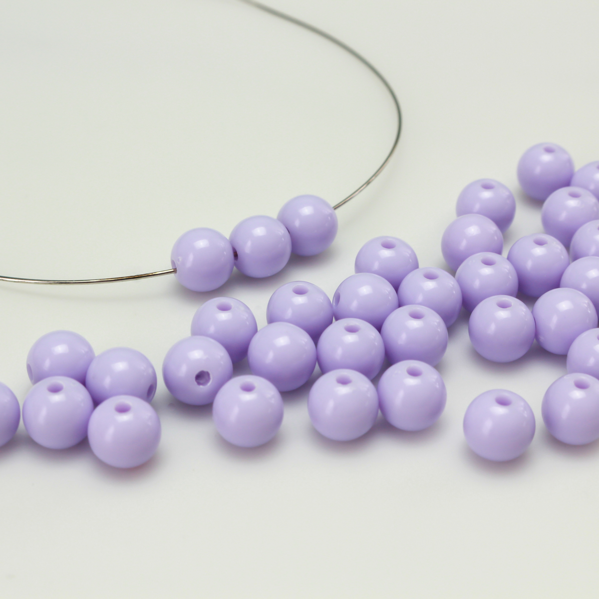 Round pale purple opaque beads that are 8mm in diameter with a 1.5mm hole size. 