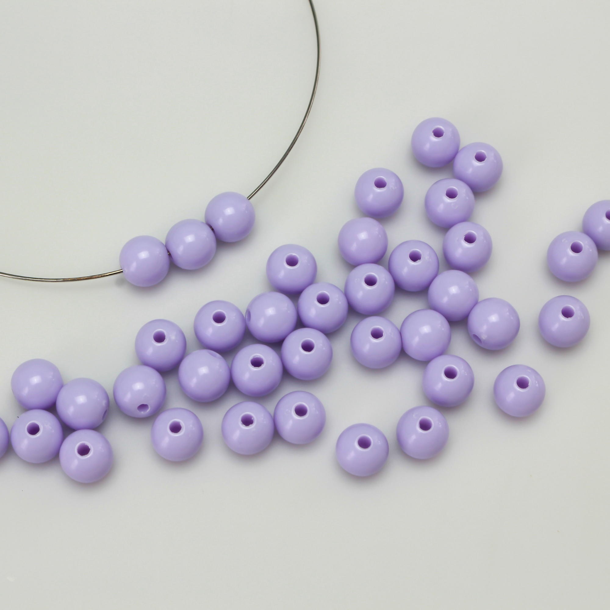 Round pale purple opaque beads that are 8mm in diameter with a 1.5mm hole size. 
