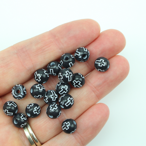 Black acrylic beads with a white etched cross design. The beads are 8mm round with a 2mm hole size.