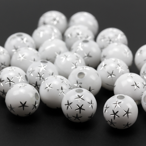 8mm round white opaque beads that have a silver star design etched into them