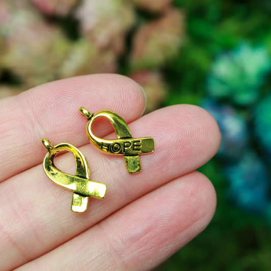 Gold awareness ribbon charms with the word "HOPE" engraved on the ribbon, 18mm long