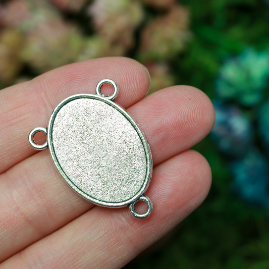 Flat oval rosary centerpiece cabochon setting in an antiqued silver tone color. This is a plain edge bezel cup with a 25mm x 18mm tray