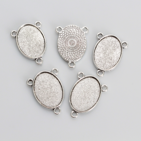 Flat oval rosary centerpiece cabochon setting in an antiqued silver tone color. This is a plain edge bezel cup with a 25mm x 18mm tray