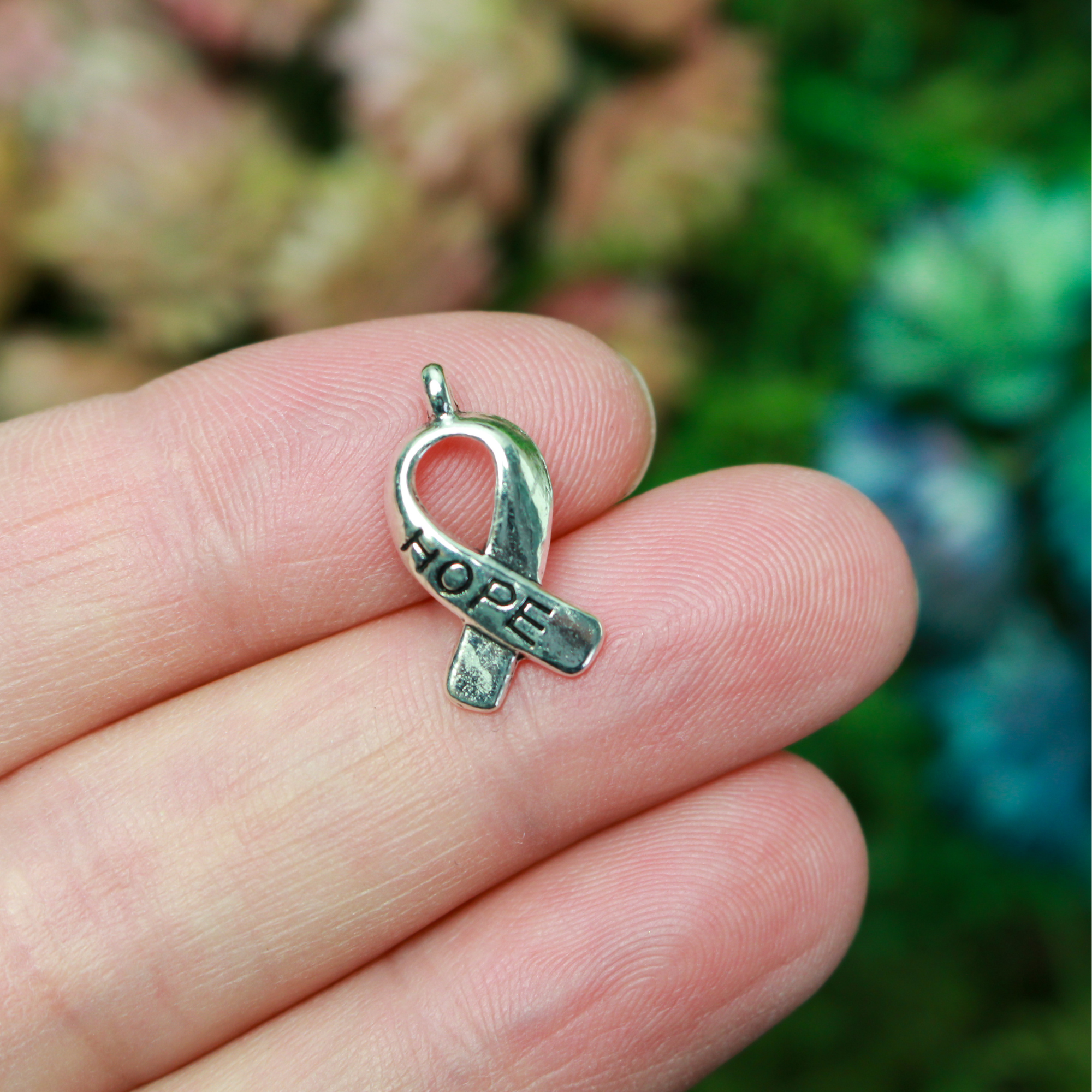 Silver awareness ribbon charms with the word "HOPE" engraved on the ribbon, 18mm long