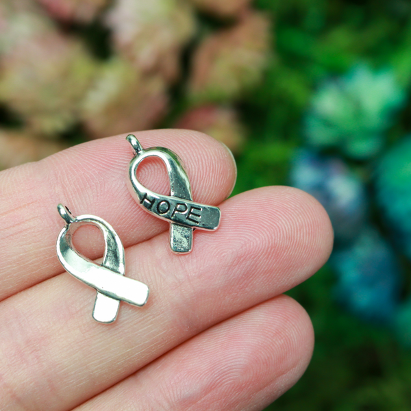 Silver awareness ribbon charms with the word "HOPE" engraved on the ribbon, 18mm long