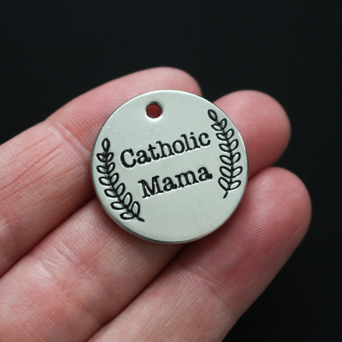 Stainless steel one inch round charm engraved with "Catholic Mama".