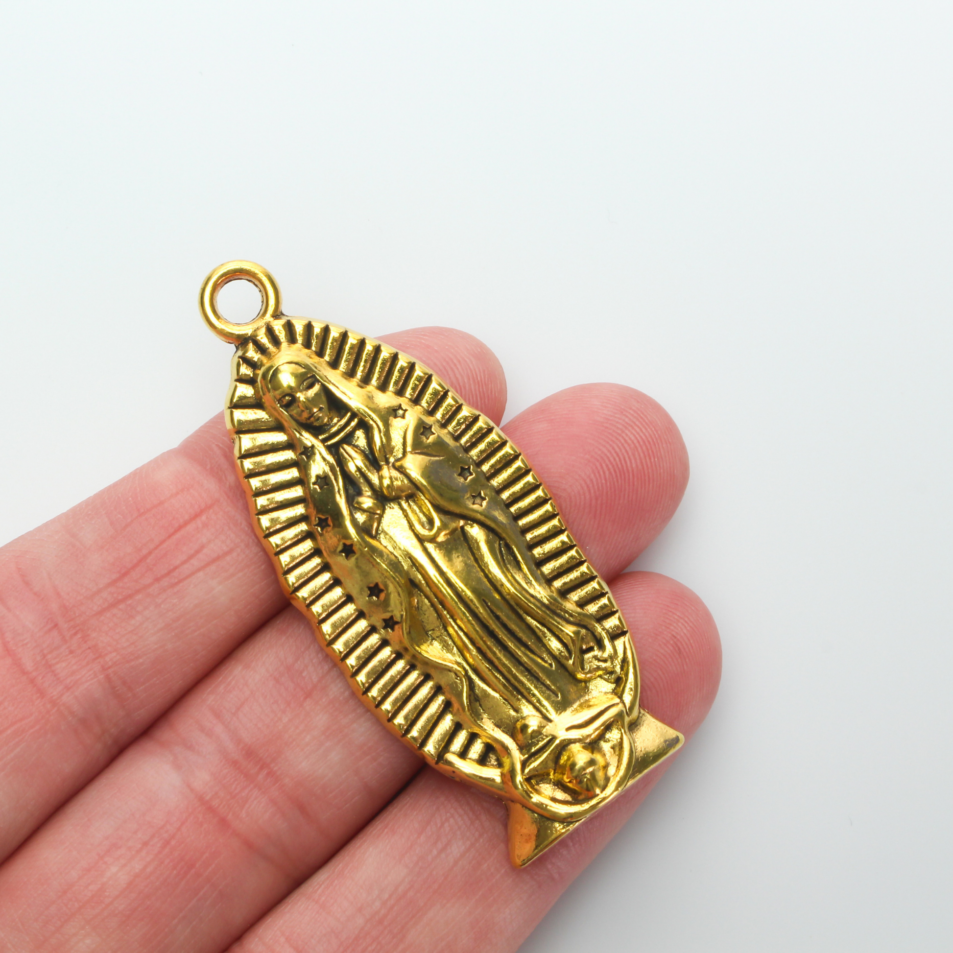A beautifully detailed pendant of Our Lady of Guadalupe. This large charm is two inches long with a flat, plain back