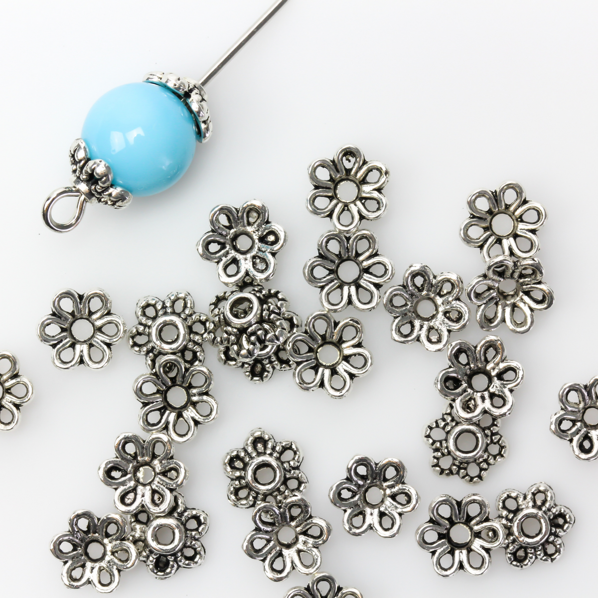 Flower shaped zinc alloy antiqued silver bead caps that are 6mm by 2.3mm, they can fit beads 8mm - 10mm