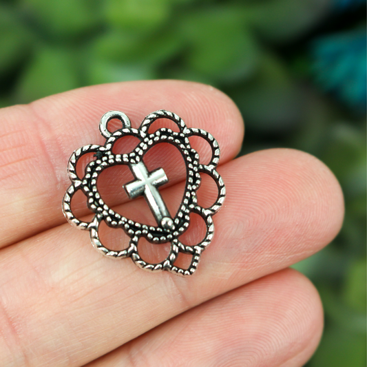 silver heart shaped charm with cross in center